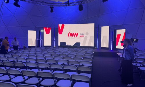 TEDELEC Event réalise la prestation technique complète pour le salon INNN 2023 à Niort, comprenant l'installation des écrans LED, l'éclairage et la gestion de la scène. Une salle vide préparée pour l'événement INNN 2023 à Niort, avec des écrans LED et une scène installés, éclairés par des lumières bleues. Prestation technique assurée par TEDELEC Event.